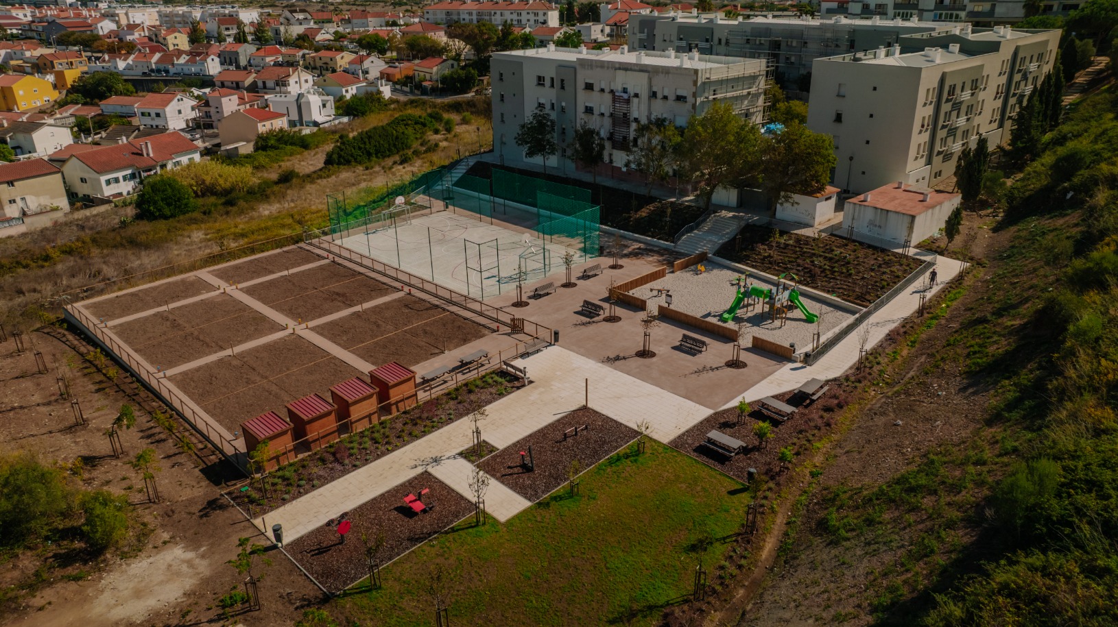 Vista aérea da requalificação urbana no Bairro Alice Cruz com hortas comunitárias, campo desportivo, parque infantil e zonas de lazer criadas pela Uni