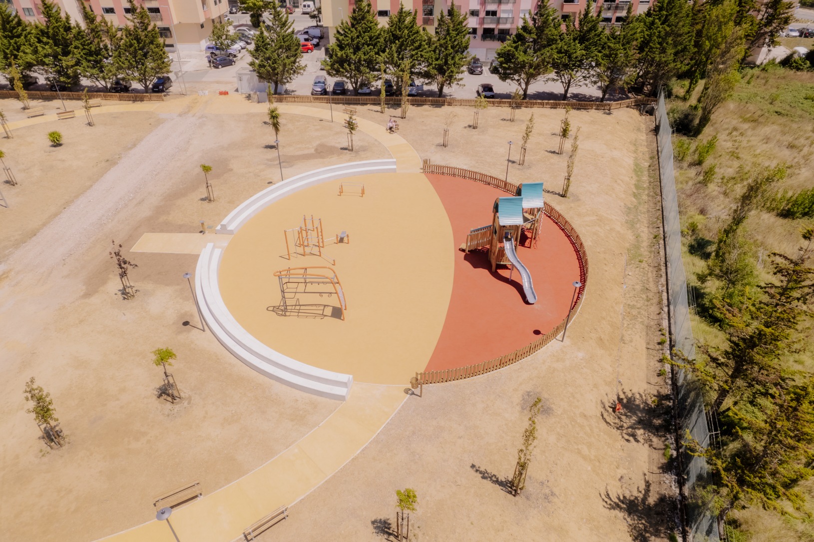 Parque de lazer e canino com parque infantil numa área ciruclar e com ajardinamentos ao redor