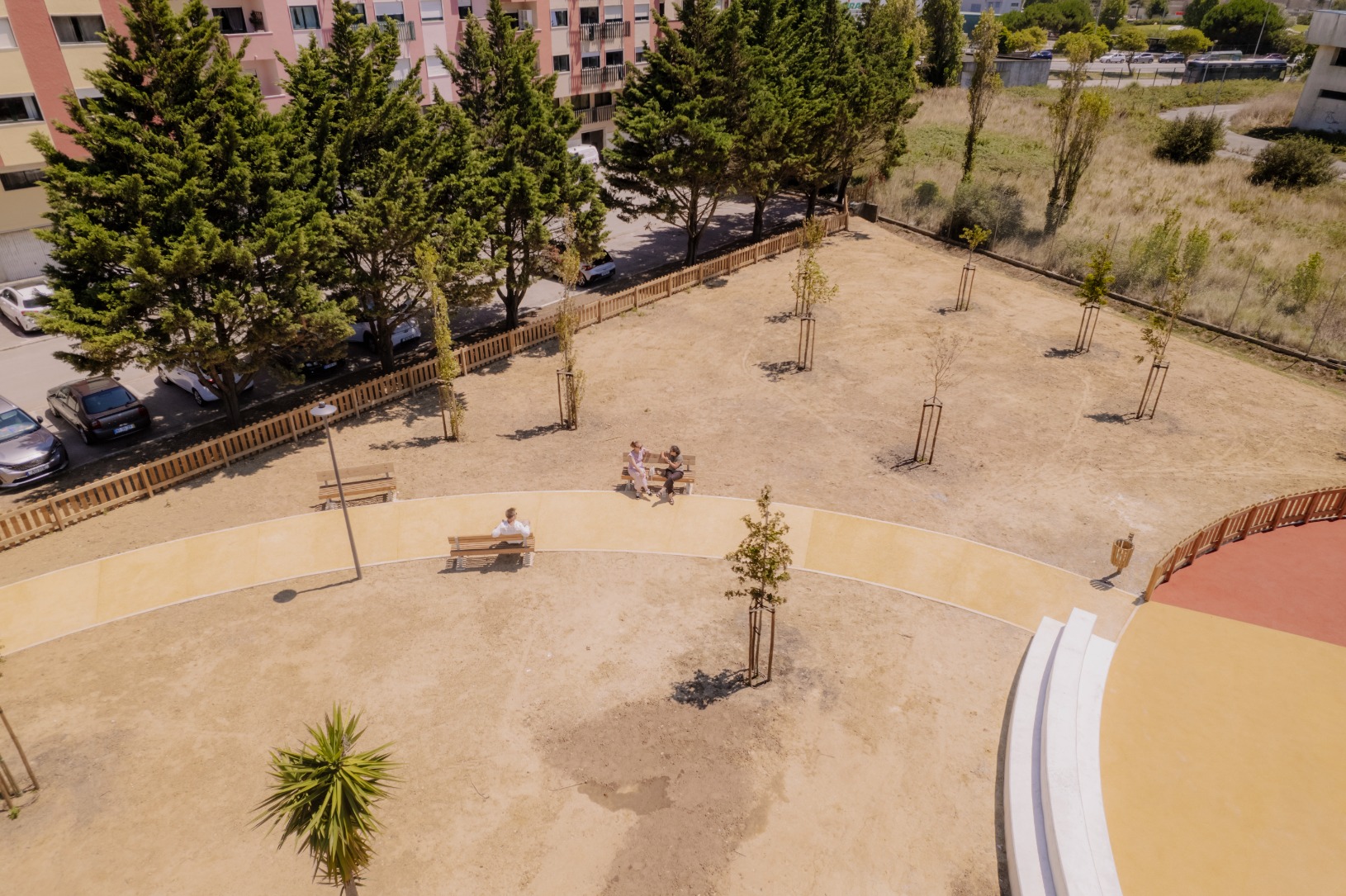 Parque de lazer e canino com parque infantil numa área ciruclar e com ajardinamentos ao redor