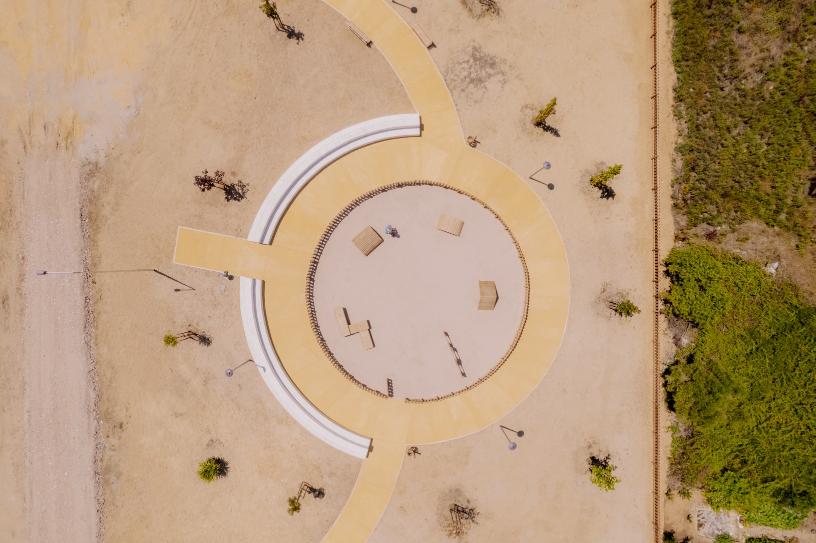 Parque de lazer e canino com parque infantil numa área ciruclar e com ajardinamentos ao redor